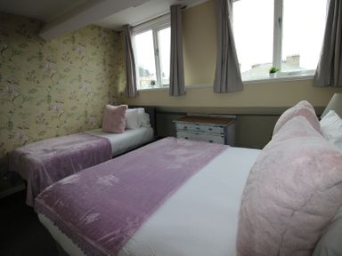 A bedroom with two beds and a dresser at Cornerhouse Apartment 5 in Llandudno