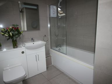 A bathroom with a shower, toilet, sink, and bathtub at Cornerhouse Apartment 5 Llandudno
