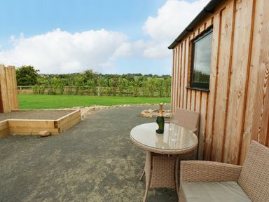 A wooden cabin with a table and chairs outside at 2 West Dunkirk Neuk Hexham