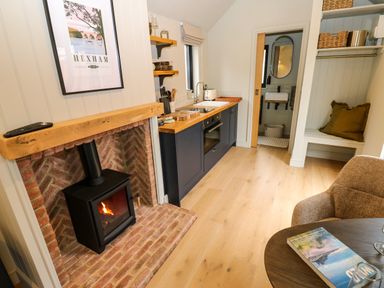 A kitchen with a fireplace and dining table at 2 West Dunkirk Neuk Hexham