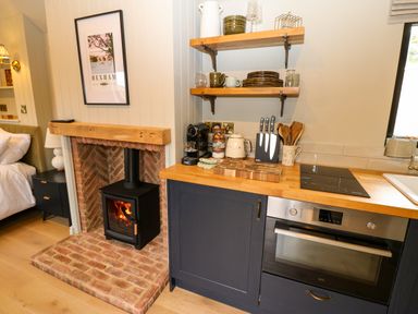 A kitchen with a stove and shelves at 2 West Dunkirk Neuk Hexham