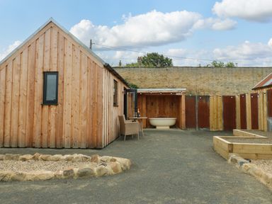 An outdoor area with a wooden house and bathtub at 2 West Dunkirk Neuk Hexham