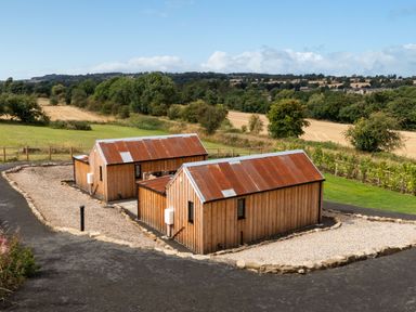 Two wooden houses with a gravel path and green landscape at 2 West Dunkirk Neuk in Humshaugh
