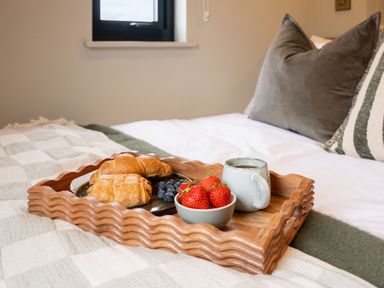 A tray with croissants and fruit on a bed at 2 West Dunkirk Neuk Humshaugh