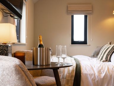 A bedroom with a champagne bucket and glasses at 2 West Dunkirk Neuk in Humshaugh