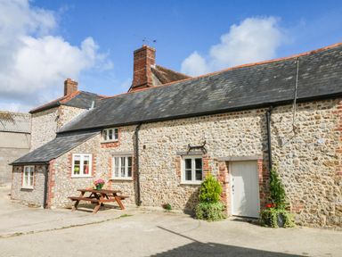 A stone building with windows and a door at The Cheese House near Charmouth