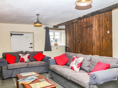 A living room with sofas and a coffee table at The Cheese House near Charmouth
