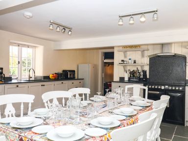 A kitchen with a dining table and chairs at The Cheese House near Charmouth
