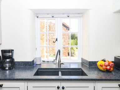 A kitchen with sink, coffee maker, and fruit bowl at The Cheese House near Charmouth