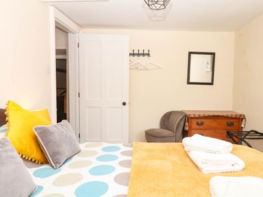 A bedroom with a bed and chair at The Cheese House near Charmouth