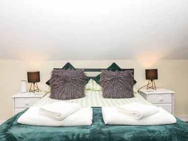 A bedroom with a bed and pillows at The Cheese House near Charmouth