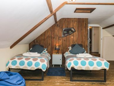 A bedroom with two single beds and a side table at The Cheese House near Charmouth