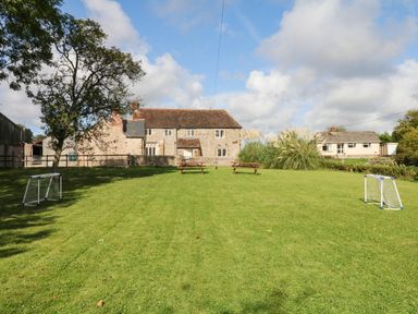 An outdoor area with a house and goal posts at The Cheese House near Charmouth