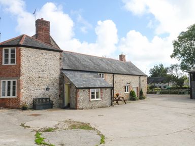 A house with a slate roof and outdoor seating area at The Cheese House near Charmouth