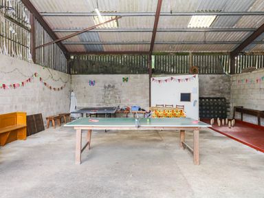 A games room with a table tennis table and benches at The Cheese House near Charmouth