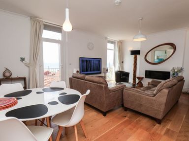 A living room with a sofa and dining table at 26 Metropole Towers in Whitby