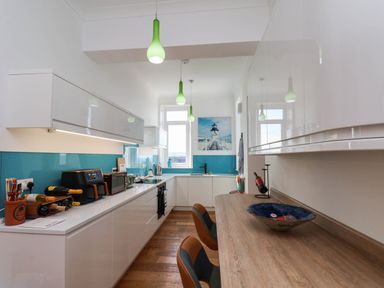 A kitchen with white cabinets and a wooden counter at 26 Metropole Towers in Whitby