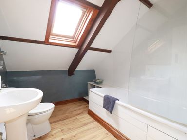A bathroom with a sink and bathtub at Honey Bee Cottage in Menheniot