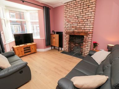 A living room with a television and a fireplace at Portobell House in Bridlington