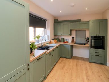 A kitchen with cabinets and sink at Portobell House in Bridlington