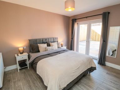 A bedroom with a bed and sliding doors to an outdoor area at Portobell House in Bridlington