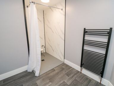 A wet room with a shower and towel rail at Portobell House in Bridlington