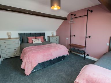 A bedroom with a bed, nightstands, and a dresser at Portobell House in Bridlington