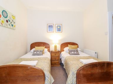 A bedroom with two single beds and a lamp at Irt Cottage in Seascale
