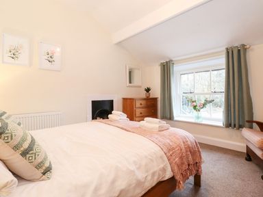 A bedroom with a bed and window at Irt Cottage in Seascale