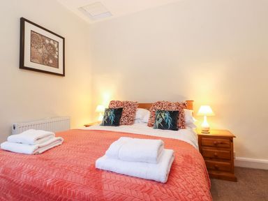 A bedroom with a bed and bedside table at Irt Cottage in Seascale