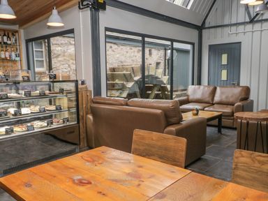 A cafe with couches and a display case at Irt Cottage in Seascale