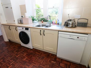 A kitchen with a sink, washing machine, and dishwasher at Prudhoe Cottage in Prudhoe