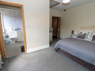 A bedroom with a view into the bathroom at Prudhoe Cottage in Prudhoe