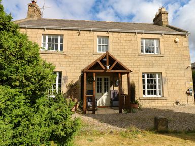 A house with a porch and garden at Prudhoe Cottage in Prudhoe