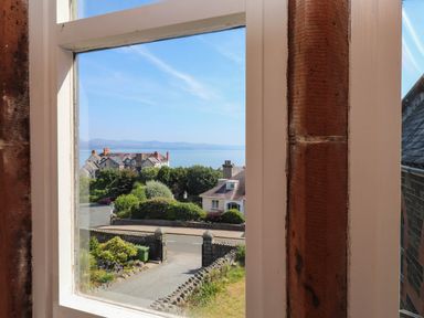 A view from a window showing houses and the ocean at Flat 16 Criccieth