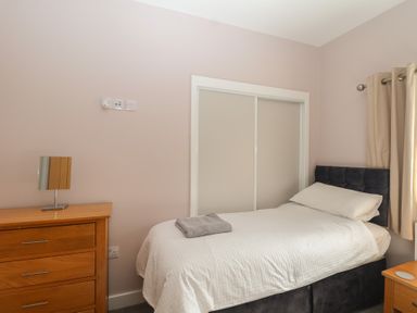 A bedroom with a bed and a dresser at The Old Dairy near Liskeard