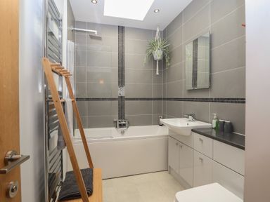 A bathroom with a bathtub and sink at The Old Dairy near Liskeard