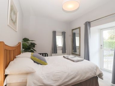 A bedroom with a bed and a window at The Old Dairy near Liskeard