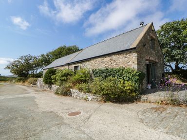 An exterior view of a stone building with a slate roof at May Cottage in St Davids