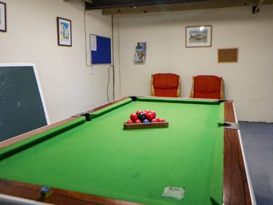 A games room with a pool table and chairs at May Cottage St Davids