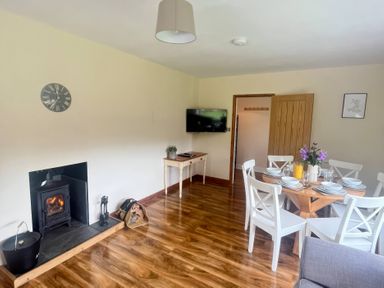 A dining room with a table and chairs at Saddleback Bungalow in Llandrindod Wells