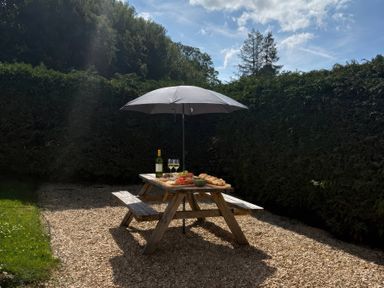 A garden with a table under an umbrella at Saddleback Bungalow Llandrindod Wells