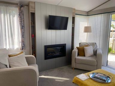 A living room with a TV and fireplace at Findhorn Lodge Peaceful Sleeps 4 in Forres