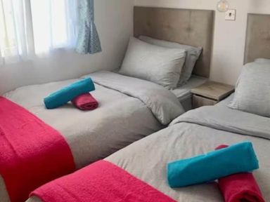 A bedroom with two beds and towels at Findhorn Lodge Peaceful Sleeps 4 in Forres