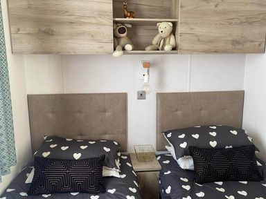 A bedroom with two beds and stuffed animals on a shelf at Findhorn Lodge Peaceful Sleeps 4 in Forres