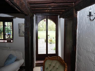A living room with a window and door leading to the garden at the property in 