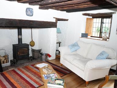 A living room with a couch and wood stove at The Old Barn in Manchester
