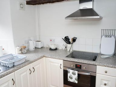 A kitchen with a stove, oven, kettle, dish rack and utensils at The Old Barn in Manchester
