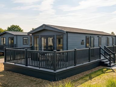 A mobile home with a deck and steps at Lovely Holiday Home On Waxham Sands, Great Yarmouth