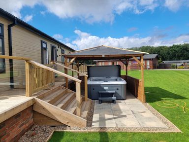 An outdoor area with a hot tub and deck at Pet Friendly 2Bed Luxury Lodge in Routh HotTub Heron Lakes Luxury Lodge Park near Beverley